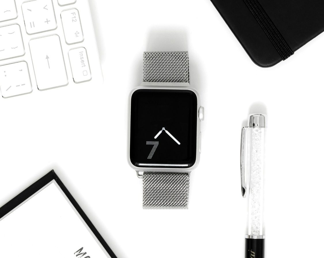 Et si le problème n’était pas votre expertise. mais la façon dont elle est perçue ? Montre connectée affichant l'heure et un fond minimaliste, sur un bureau.