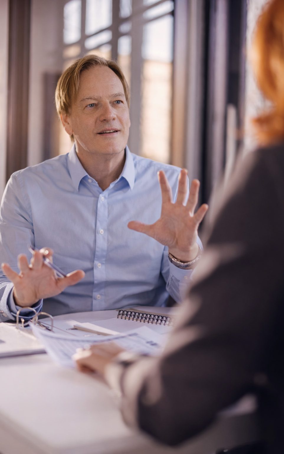 Olivier Dupont Expert en Vidéo LinkedIn et marque personnelle Un homme en chemise légère discute avec animation lors d'une réunion.